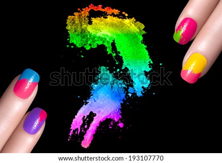 Fingers with colorful fluor nails with drops of water and crushed eye shadow. Manicure and makeup concept. Closeup image isolated on black