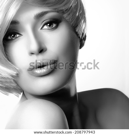 Beautiful young woman face with short hairstyle sending a kiss. Closeup monochrome portrait isolated on white