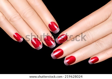 Holiday Nail Art. Luxury nail polish with glitter French manicure. Manicure and makeup concept. Closeup hands isolated on black background