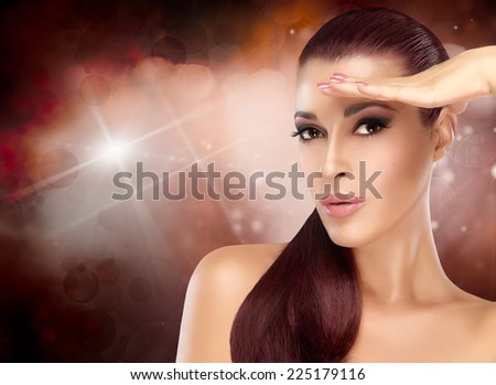 Beautiful fashion model with healthy long hair and hand on forehead like a visor. Trendy hairstyle and makeup. Beauty portrait over colorful background with copy space for text