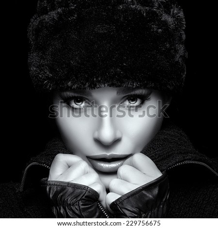 Winter Beauty. Fashion beautiful girl with trendy fur hat and mittens. High fashion portrait in black and white. Wintry style