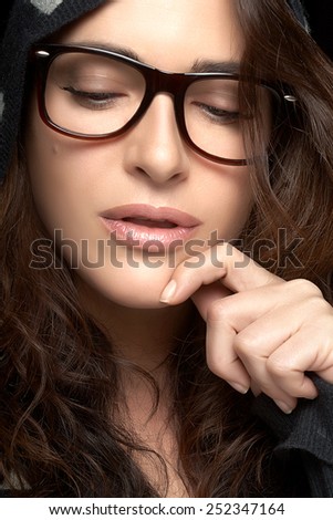 Close up Pretty Young Woman Face, with Glasses, Looking Down with One Hand on the Face. Gorgeous Brunette Fashion Model Girl. Cool Trendy Eyewear Portrait