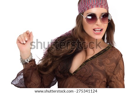 Fashionable Party Girl with Long Brown Hair Wearing Brown Dress in Hippie Style with Sunglasses and Headband. Looking at Camera, Emphasizing in Dancing, Isolated on White Background with Copy Space