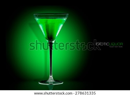 Stemmed cocktail glass with mint liquor, closeup isolated on black. Template design with sample text