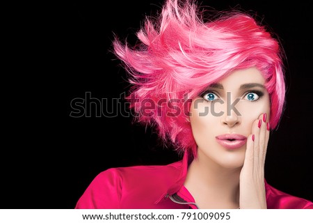Fashion model girl with stylish dyed pink hair and pursed lips with expression of surprise looking at camera. Beauty Hairstyle portrait isolated on black background with copy space for text