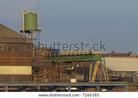 50 year old scrap metal processing factory. Everything is covered in rust and dust except for the crane that was painted a few years ago. Photographed in the warm light of a summer afternoon.