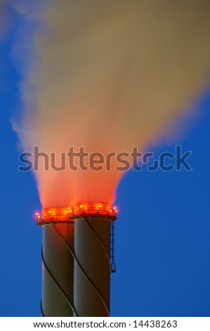 Chimney and red glowing smoke at night