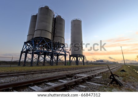 High dynamic range impression of silos and rail tracks at sunrise in the Port of Rotterdam