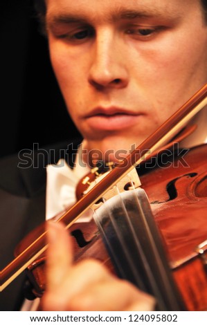 Detail of a man playing a violin in a live performance