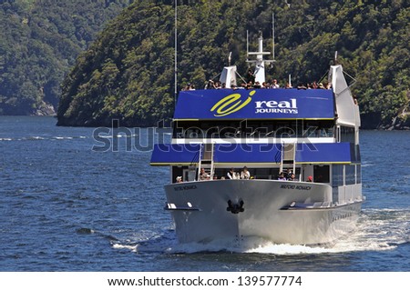 MILFORD SOUND, NEW ZEALAND, JANUARY 8: Tourists enjoy the sights from a launch on January 8, 2011 at Milford Sound in New Zealand. Milford is one of the country\'s  favourite tourist destinations.