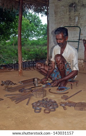 TAMIL NADU, INDIA, circa 2009: Unidentified man hammers out steel in his blacksmith's shop, circa 2009 in Tamil Nadu, India. Must of India's economy still relies on hand tools and skilled tradesmen.