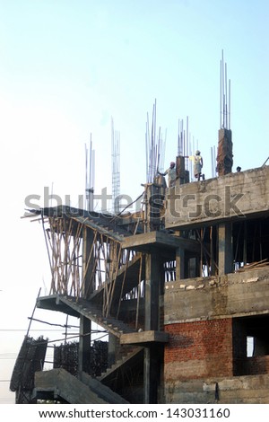 Men on skyline of construction site, Tamil Nadu, South India