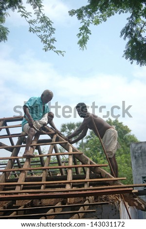TAMIL NADU, INDIA, circa 2009: Carpenters working on a roof circa 2009 in Tamil Nadu, India. Much of India\'s economy still relies on hand tools and skilled tradesmen.