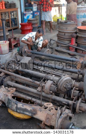 TAMIL NADU, INDIA, circa 2009: Unidentified man working on axles in a city street, circa 2009 in Tamil Nadu, India. Much of India\'s economy still relies on hand tools and skilled tradesmen.