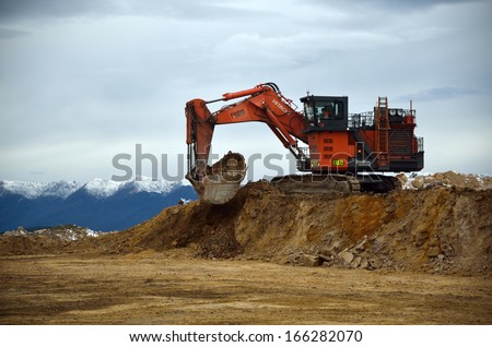 WESTPORT, NEW ZEALAND, JULY 12, 2013: A 190 ton digger loads a 130 ton truck with rock overburden at Stockton open cast coal mine on July 12, 2013 near Westport, New Zealand.