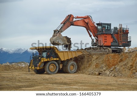 WESTPORT, NEW ZEALAND, AUGUST 31, 2013: 190 ton digger loading a 130 ton tiptruck with overburden at an open cast coal mine on August 31, 2013 near Westport, New Zealand