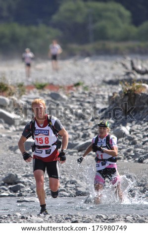 SOUTH ISLAND, NEW ZEALAND, FEBRUARY 12, 2011: John Mudgway just keeps ahead of Elina Ussher in the mountain leg of the 2011 Coast to Coast triathlon, West Coast, South Island, New Zealand