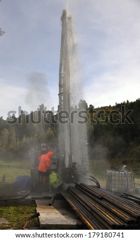 MOANA, NEW ZEALAND, MARCH 18, 2010: Drilling crewmen control a small blowout at the mouth of a well for coal seam  gas near Moana, New Zealand.