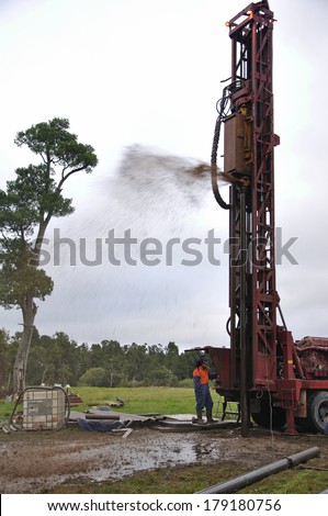 MOANA, NEW ZEALAND, MARCH 9, 2010: Drilling rig expels mud and water during drilling operation for coal seam  gas near Moana, West Coast, New Zealand.