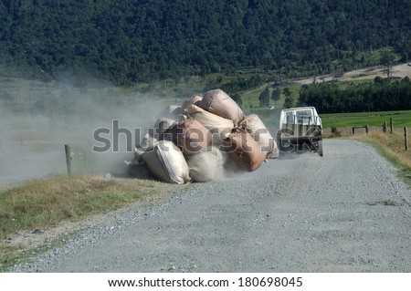 Trailer load of wool sacks falling off a farm trailer