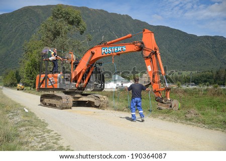 GREYMOUTH, NEW ZEALAND, APRIL 1, 2014: Workers lay a fibre optic cable as part of a government scheme to bring high-speed internet connections to rural Westland, New Zealand