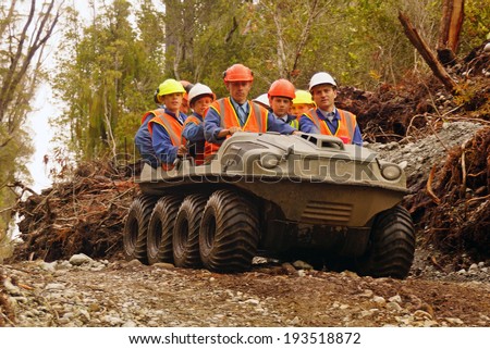 GREYMOUTH, NEW ZEALAND, 23-12-2013: Unidentified men travel in an all terrain vehicle while working in the bush on the West Coast of New Zealand
