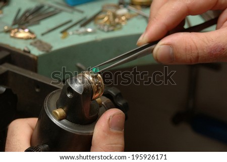 A Jeweller positions a natural emerald in a gold ring