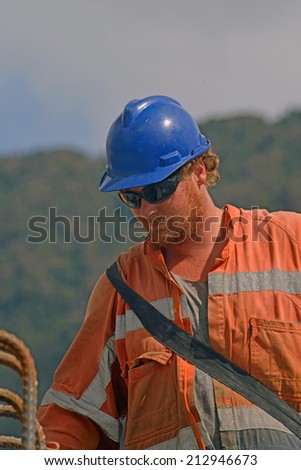 Portrait of builder at work on a concrete bridge over a small river in Westland, New Zealand