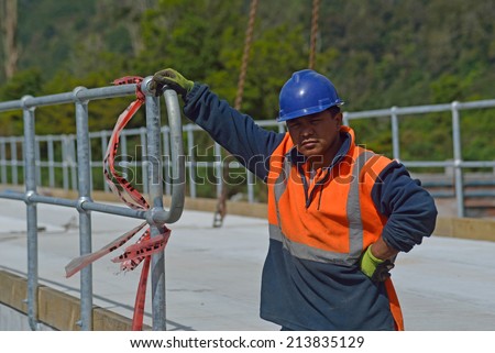 Portrait of builder on a bridge-building site at a small river in Westland, New Zealand