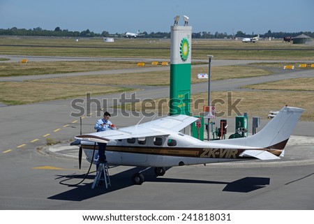 CHRISTCHURCH, NEW ZEALAND, DECEMBER 12, 2014: The unidentified pilot of a light plane refuels his plane at Christchurch International Airport on December 12, 2014