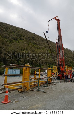 WHATAROA, NEW ZEALAND, DECEMBER 5, 2014: Drillers load a new pipe onto the drillstring while drilling to 1300 metres on the Deep Fault Drilling Project, Whataroa, New Zealand.