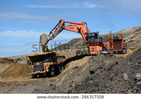 WESTPORT, NEW ZEALAND, MARCH 11, 2015: 190 ton digger loads rock from a layer of overburden at open cast coal mine on March 11, 2015 near Westport, New Zealand