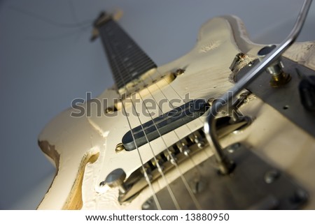 A heavily used electric guitar. Focus on black pickup.