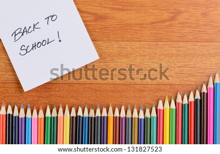 Back to school: color pencils on wood grain background note and color pencils on wood background.