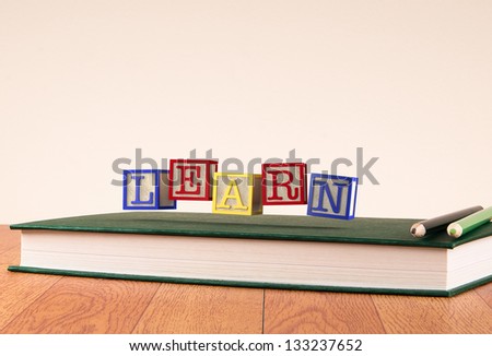 Back to school: floating wooden alphabet blocks on a book
