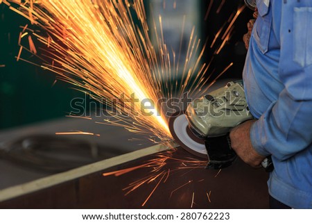 Worker preparation steel plate by hand grinding machine