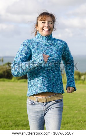 happy smiling mature woman having fun in park running and laughing