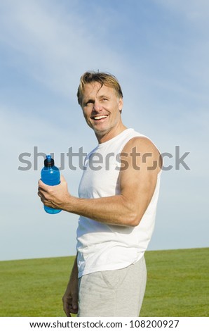 happy smiling sportsman fooling around with his water bottle.
