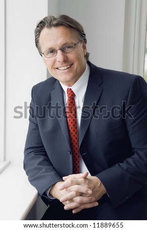A handsome smiling professional man in a smart suit.