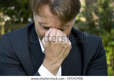 a sad businessman begins crying after hearing bad news