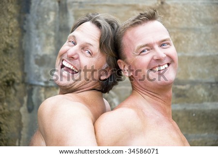 Two mature gay men are laughing and fooling around together.