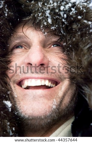A happy smiling male adventurer with stubble and furry hooded coat