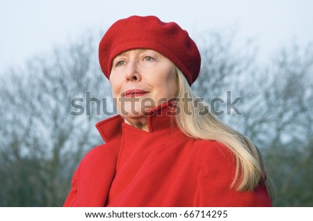 Beautiful older woman wearing a red coat and hat
