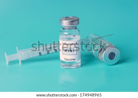Flu vaccine and syringe on aqua background.