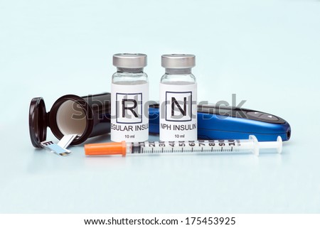 Regular and NPH insulin with insulin syringe and glucometer on light blue background.