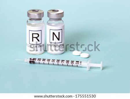 Regular and NPH insulin with insulin syringe and diabetes pills on light blue background.