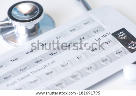 Stethoscope and daily schedule blister pack with medication.