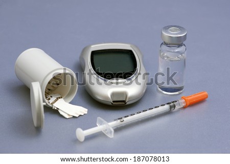 Diabetic testing supplies with syringe and insulin.