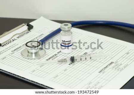 Influenza vaccine with syringe, stethoscope, and patient chart.