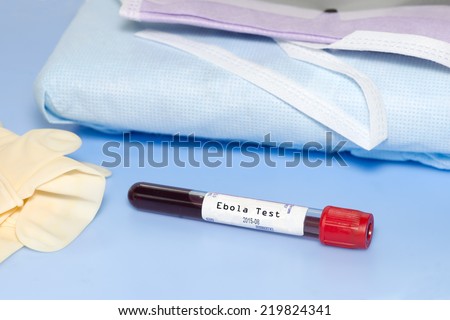 Blood collection tube with Ebola test label and personal protection equipment on blue background.